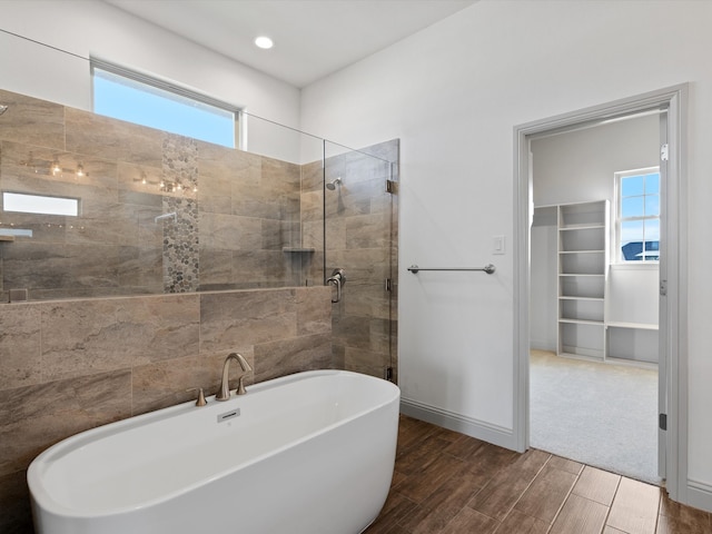 bathroom with shower with separate bathtub and plenty of natural light