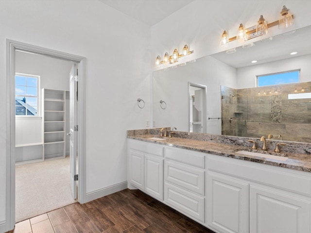 bathroom with hardwood / wood-style flooring, vanity, and an enclosed shower