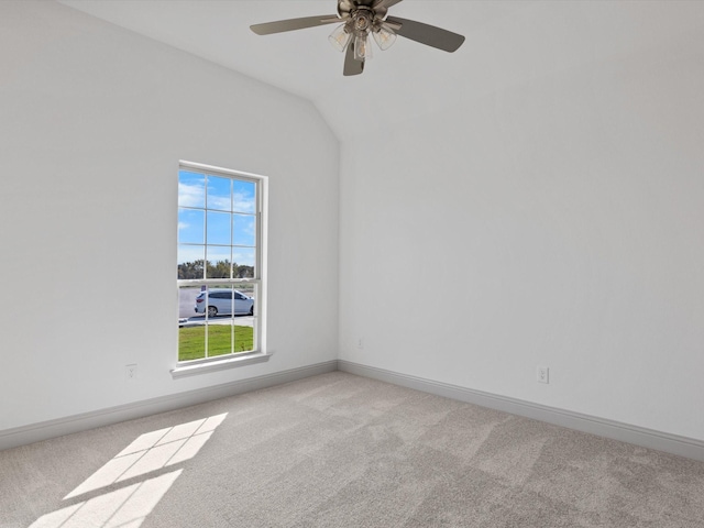 empty room featuring lofted ceiling, light colored carpet, and ceiling fan