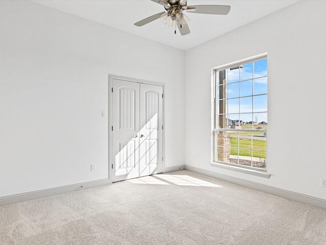 carpeted empty room featuring ceiling fan and a healthy amount of sunlight