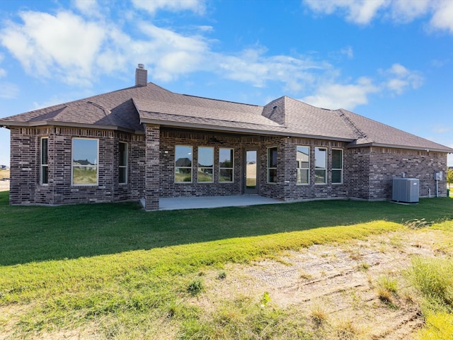 rear view of house with a yard, central air condition unit, and a patio area