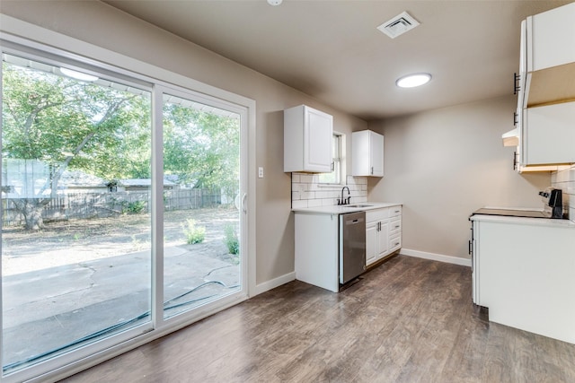 kitchen with sink, hardwood / wood-style flooring, tasteful backsplash, white cabinets, and stainless steel dishwasher