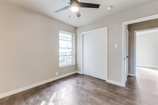 unfurnished bedroom featuring hardwood / wood-style floors, a closet, and ceiling fan