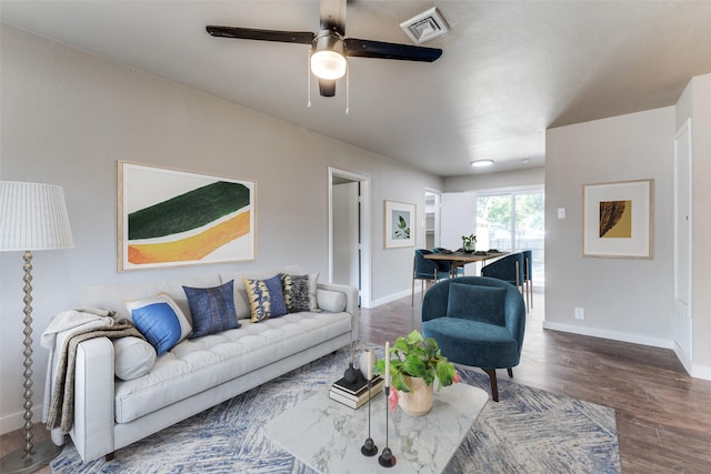 living room featuring ceiling fan and dark hardwood / wood-style flooring