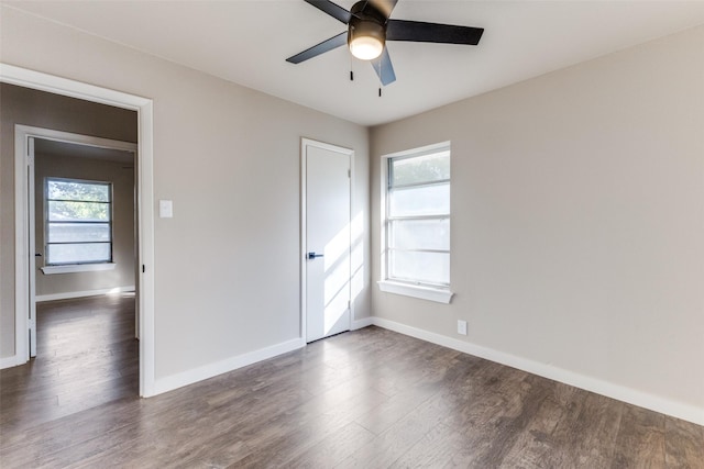 unfurnished room featuring dark wood-type flooring and ceiling fan