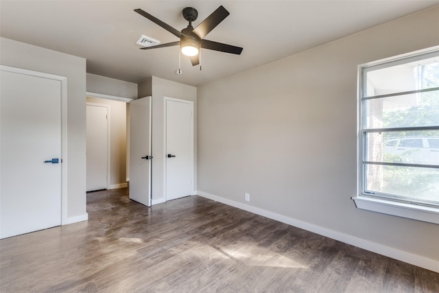 unfurnished bedroom with dark wood-type flooring and ceiling fan