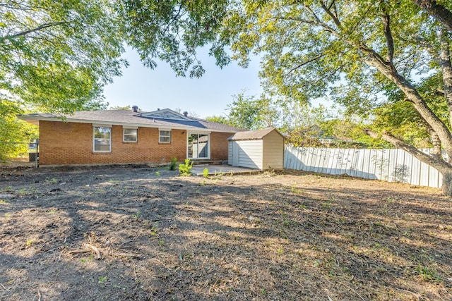 rear view of property with a storage unit