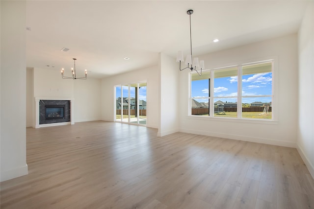 unfurnished living room featuring a high end fireplace, light hardwood / wood-style flooring, and a healthy amount of sunlight