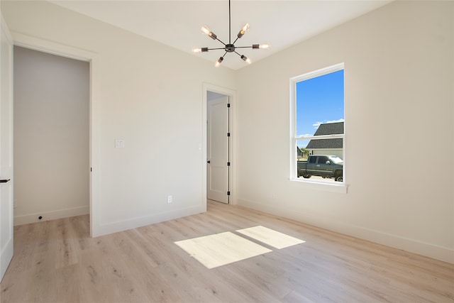 unfurnished bedroom with light wood-type flooring and a chandelier