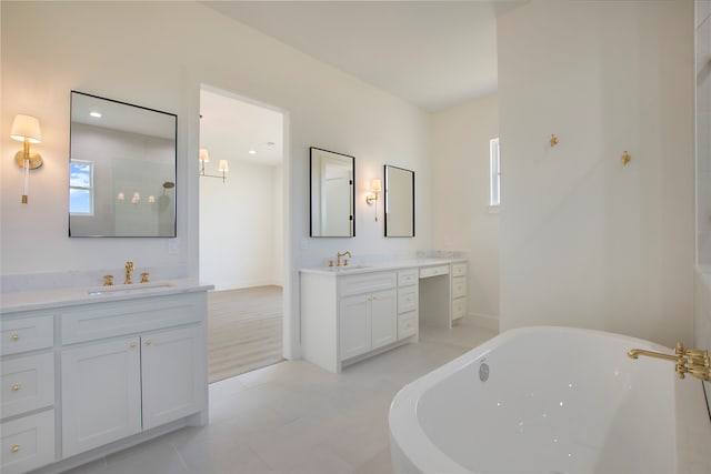 bathroom featuring vanity, tile patterned flooring, and a tub