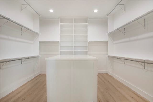 walk in closet with light hardwood / wood-style flooring