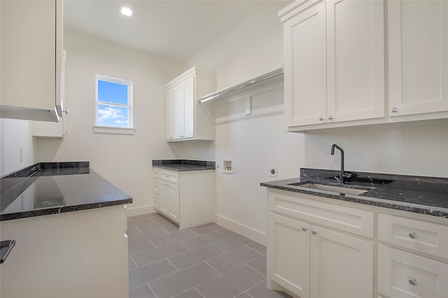 laundry area with hookup for a washing machine, hookup for an electric dryer, sink, and cabinets