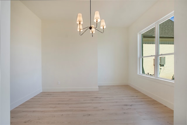 unfurnished room featuring light hardwood / wood-style flooring and a chandelier