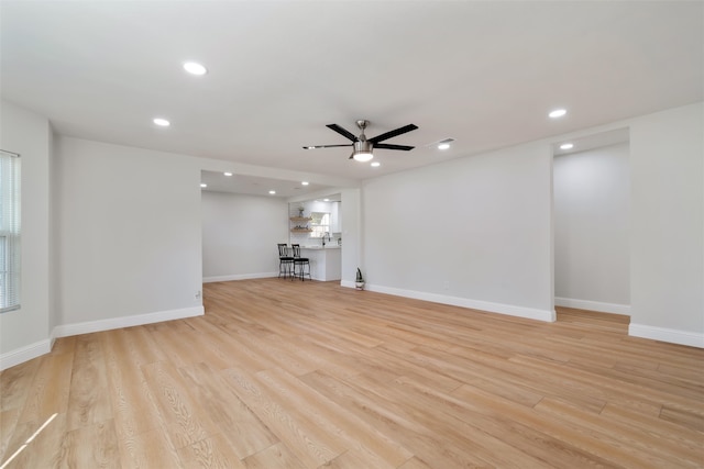 unfurnished living room featuring ceiling fan and light wood-type flooring