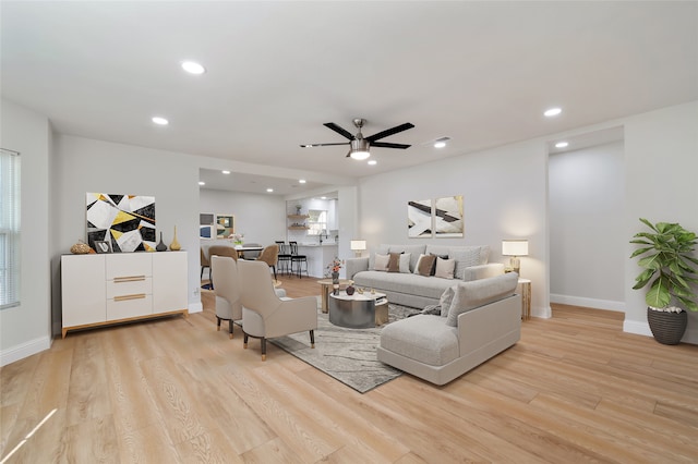 living room with light wood-type flooring and ceiling fan