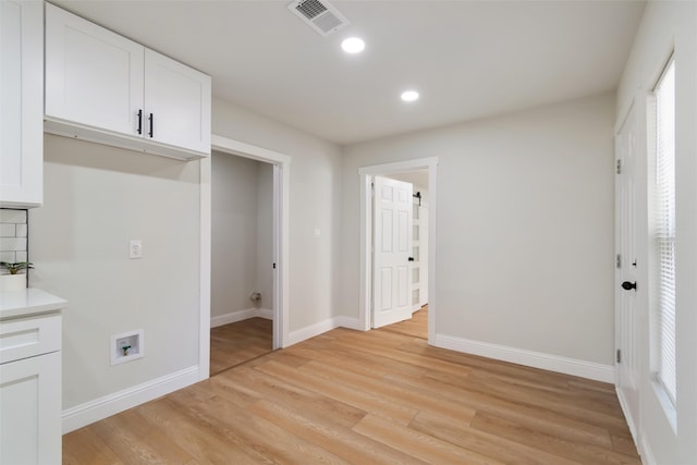 interior space with washer hookup and light hardwood / wood-style flooring