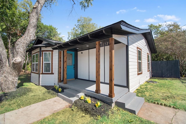 view of front of home featuring covered porch and a front yard