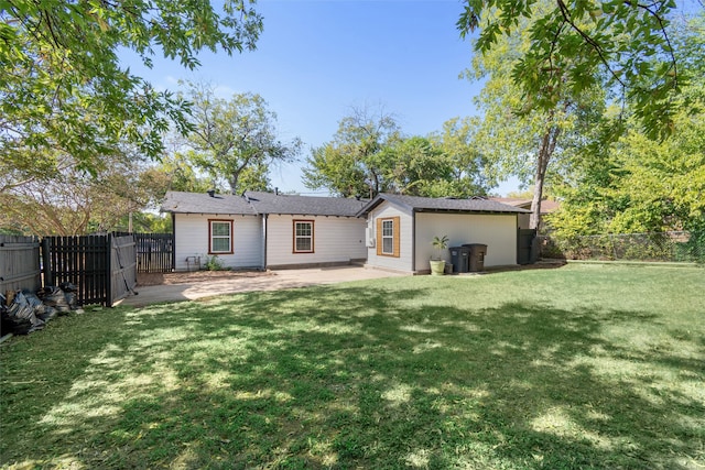 rear view of house with a lawn and a patio