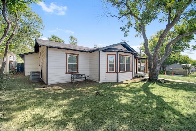 exterior space with central AC and a lawn