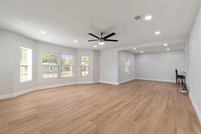 unfurnished living room featuring ceiling fan, light wood-type flooring, and a wealth of natural light