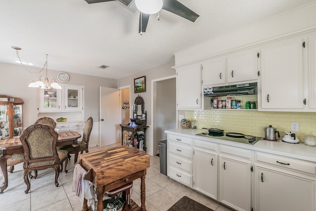 kitchen featuring electric stovetop, pendant lighting, white cabinetry, light tile patterned floors, and backsplash