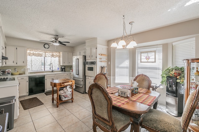 dining area with plenty of natural light, ceiling fan with notable chandelier, and light tile patterned floors