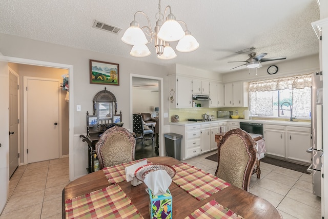 tiled dining room featuring a textured ceiling, ceiling fan with notable chandelier, and sink