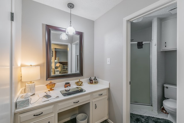 bathroom featuring a textured ceiling, a shower with door, vanity, and toilet