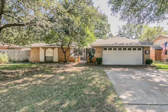 ranch-style house featuring a garage, cooling unit, and a front lawn