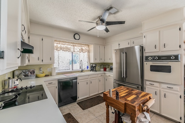 kitchen with light tile patterned flooring, black appliances, sink, and white cabinetry