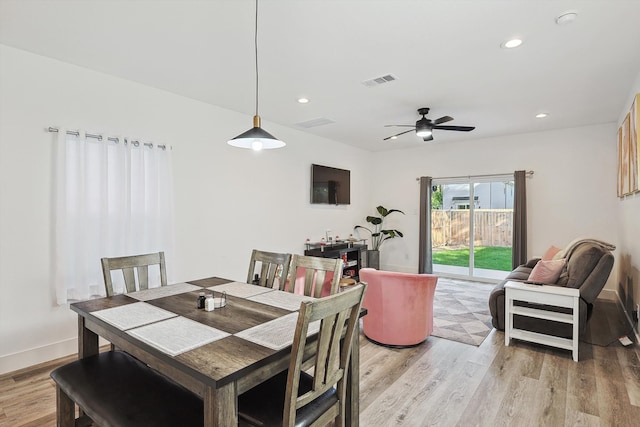 dining space with light hardwood / wood-style floors and ceiling fan