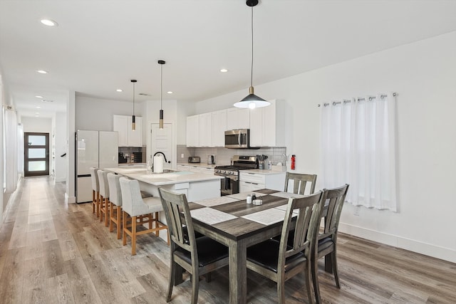 dining room featuring sink and light hardwood / wood-style floors