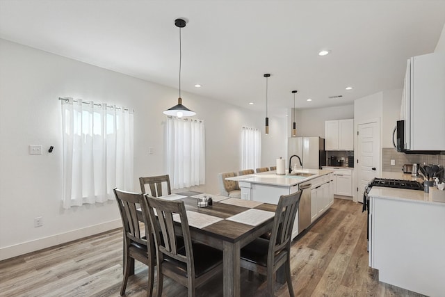 dining area featuring light hardwood / wood-style floors, a healthy amount of sunlight, and sink