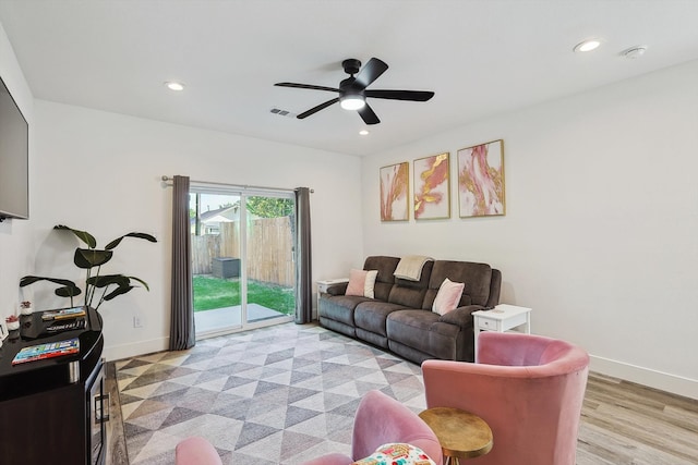 living room featuring ceiling fan and light hardwood / wood-style flooring