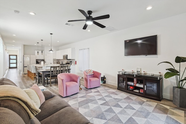 living room featuring light hardwood / wood-style floors and ceiling fan