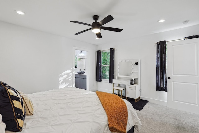 carpeted bedroom featuring ensuite bath and ceiling fan