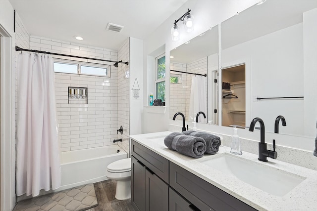 full bathroom with vanity, toilet, shower / bath combo with shower curtain, and plenty of natural light