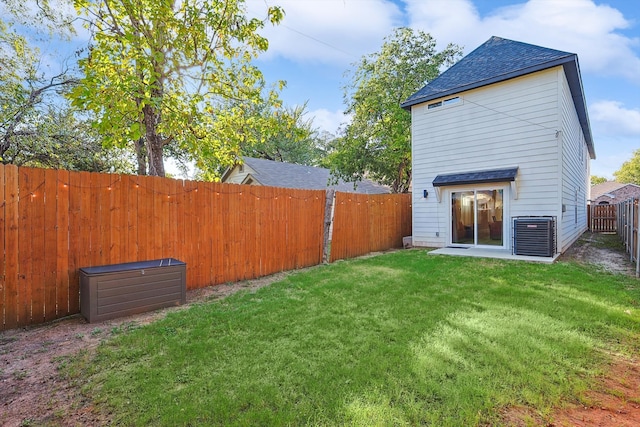 back of property with central air condition unit and a lawn