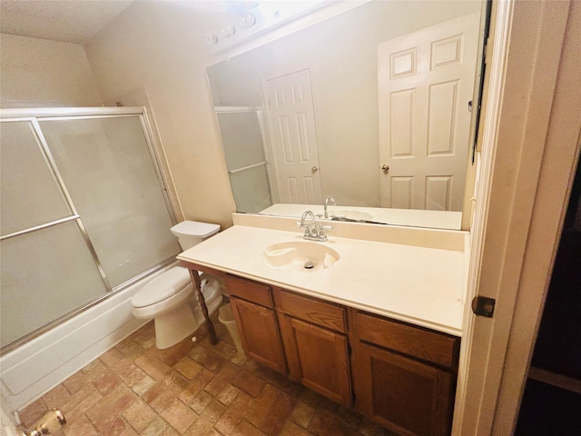 full bathroom featuring combined bath / shower with glass door, vanity, and toilet