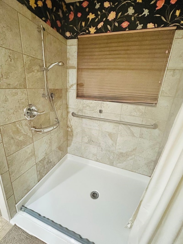 bathroom with tile patterned flooring and tiled shower