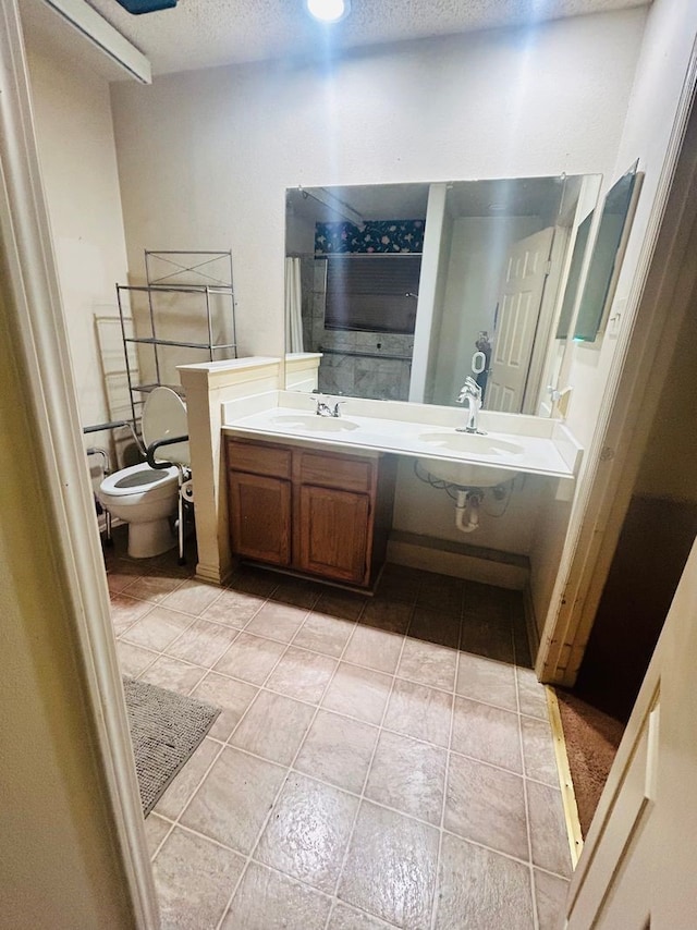 bathroom featuring vanity, a bidet, a textured ceiling, tile patterned floors, and toilet