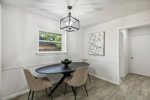 dining room with wood-type flooring and an inviting chandelier