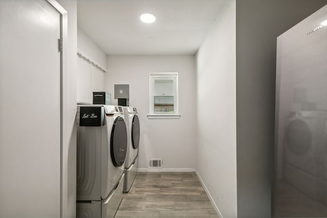 washroom with washer and dryer and light hardwood / wood-style floors