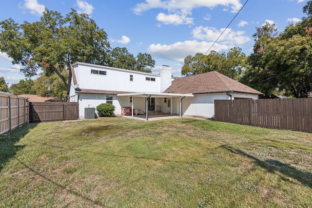 back of property with a lawn, central air condition unit, and a patio