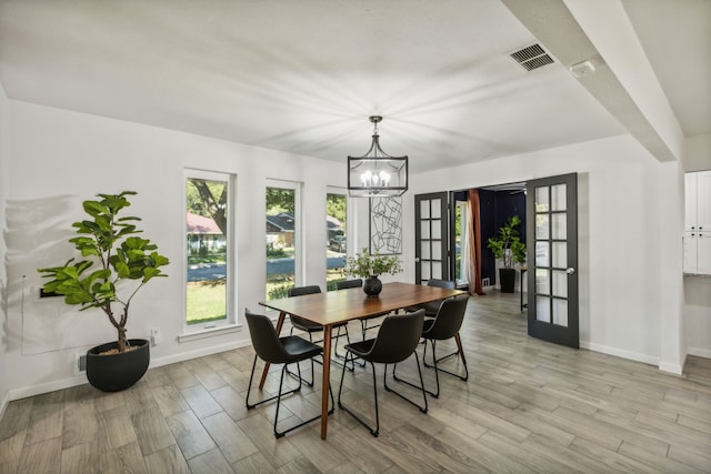 dining space featuring a notable chandelier, light hardwood / wood-style floors, and french doors