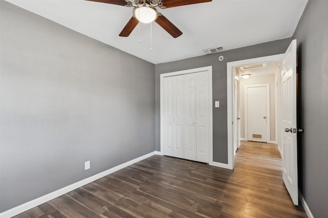 unfurnished bedroom with a closet, ceiling fan, and dark hardwood / wood-style floors