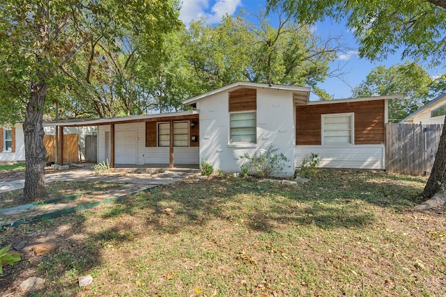 view of front of property featuring a front lawn and a carport