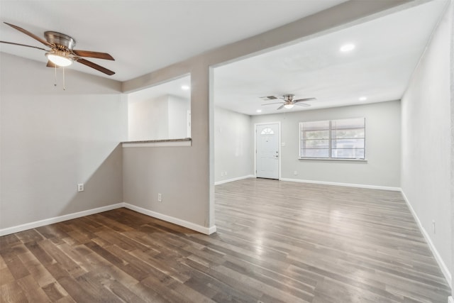 spare room featuring ceiling fan and dark wood-type flooring