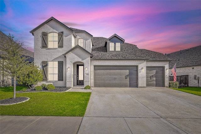 view of front of property with a garage and a yard