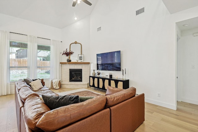 living room with high vaulted ceiling, light hardwood / wood-style flooring, and ceiling fan